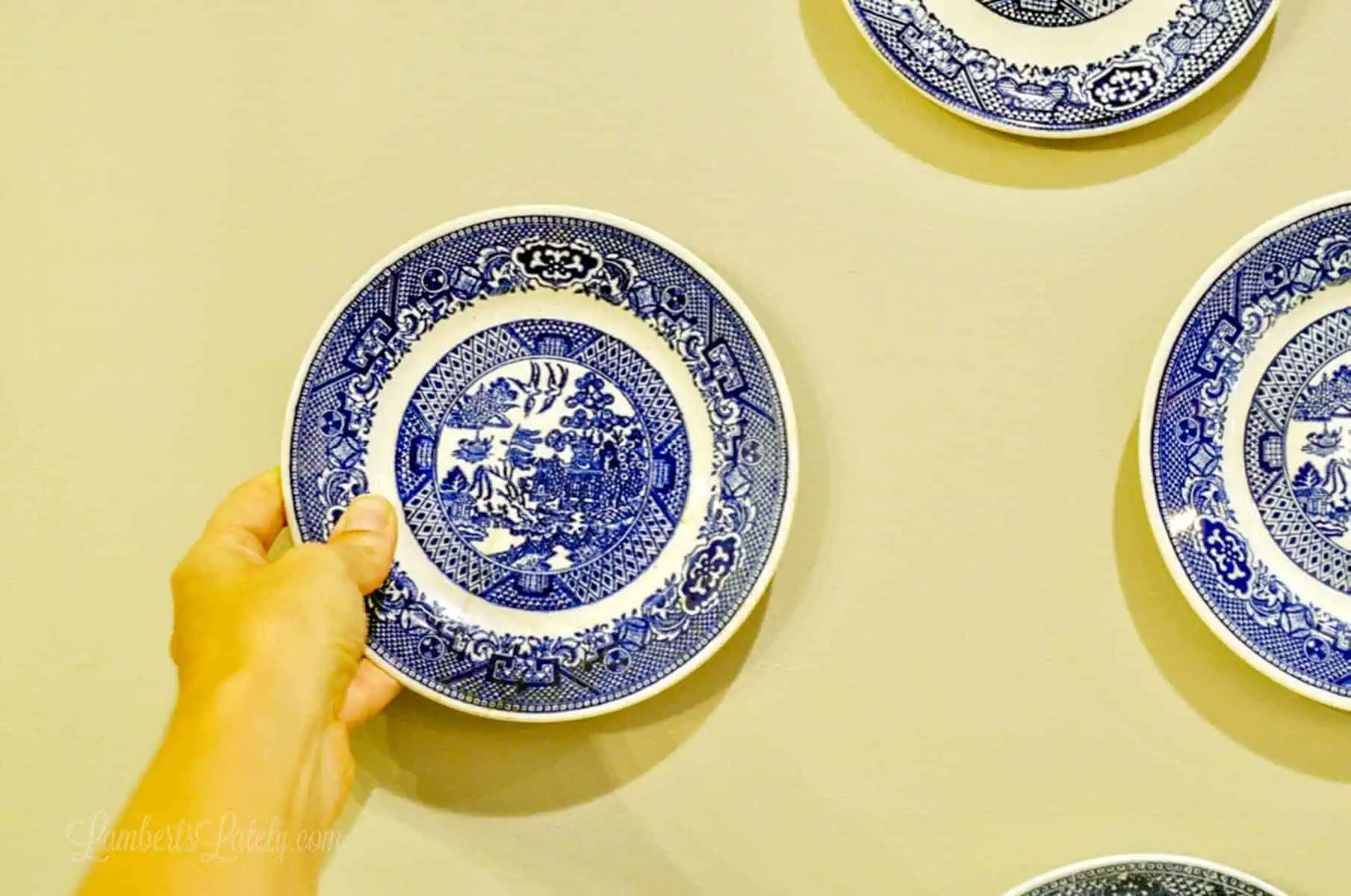 holding a plate up to the wall.