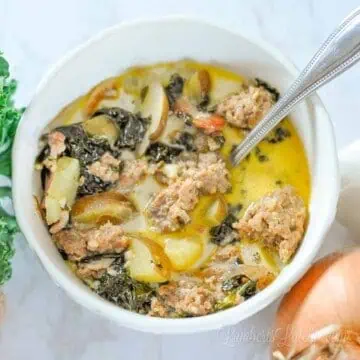 looking down on a bowl of zuppa toscana with a spoon in it.