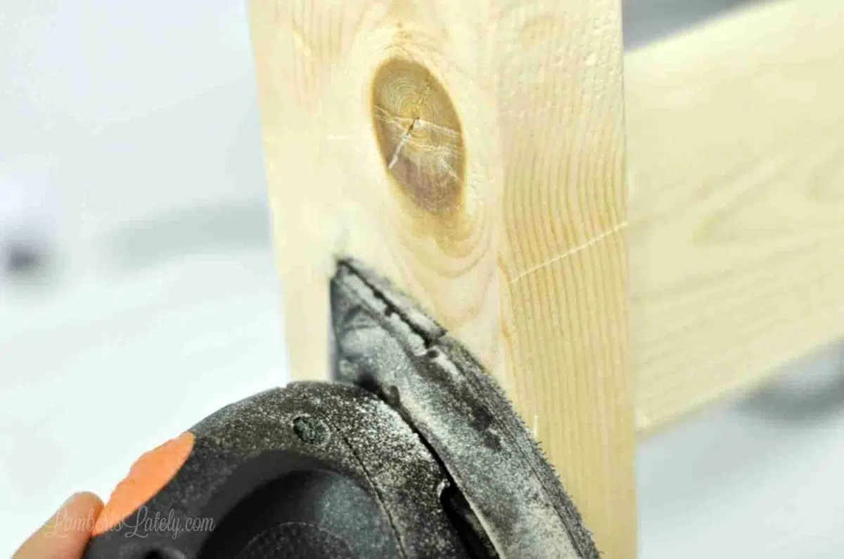 sanding a 2x4 with an orbital sander.