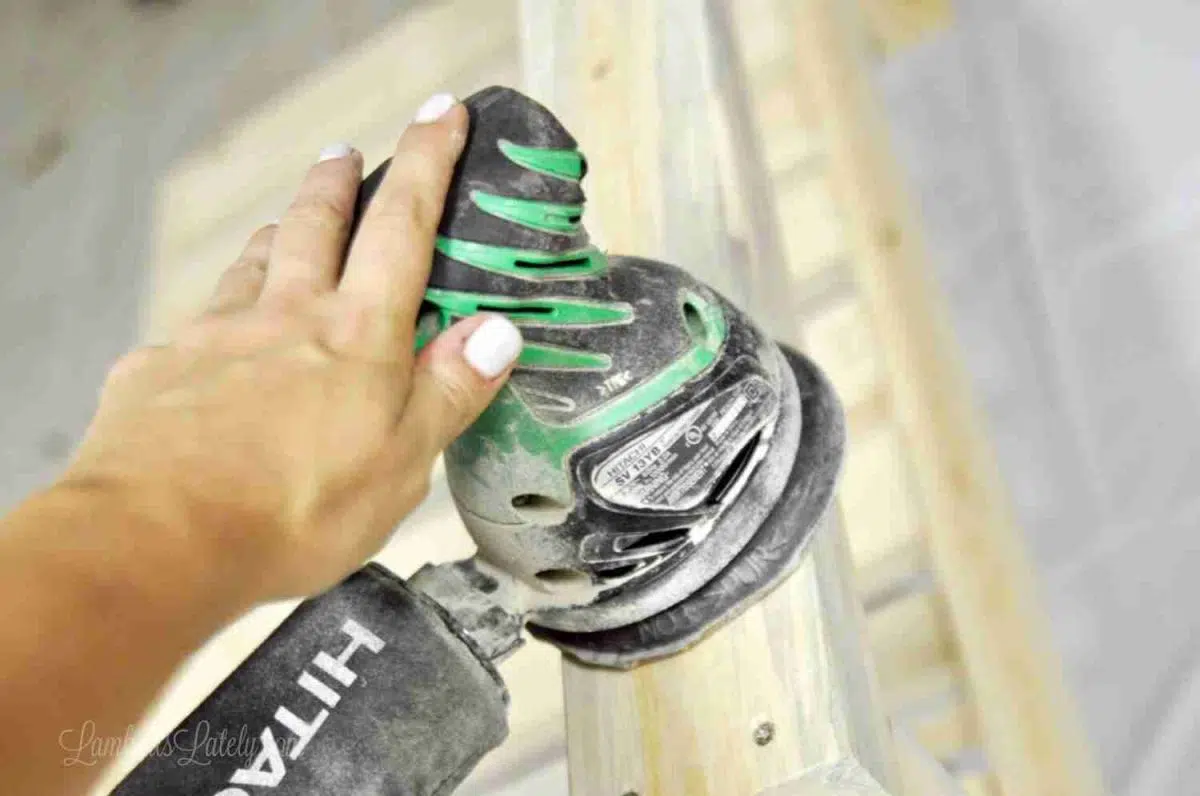 sanding the wood with an orbital sander.