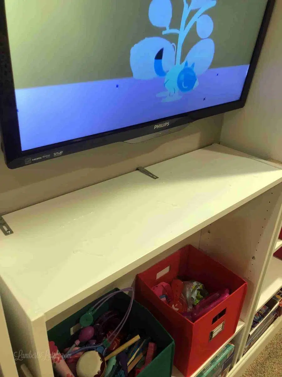 cabinet installed below tv, with metal braces.