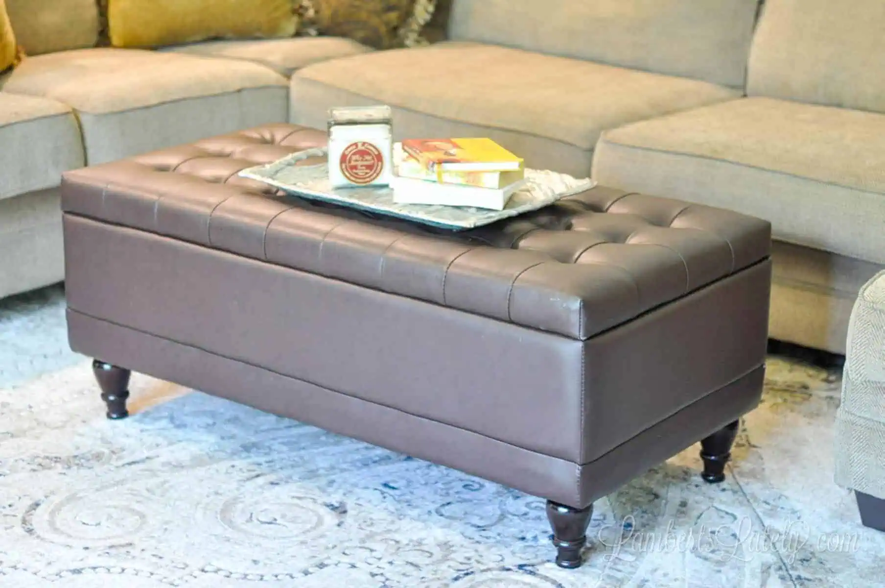 brown leather ottoman in front of a couch.