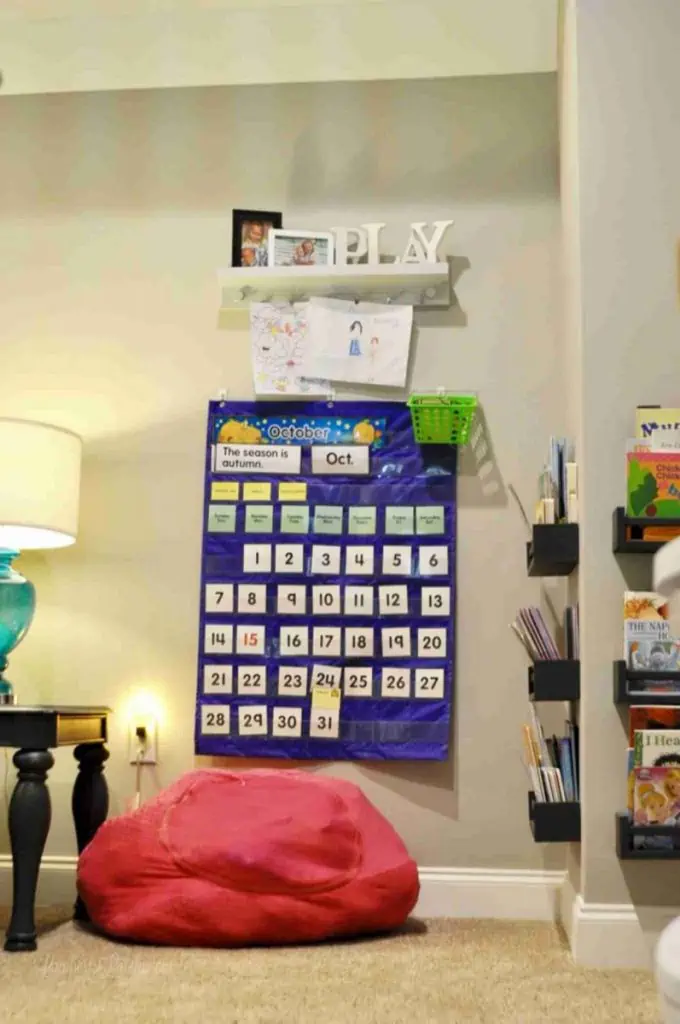 bean bag seat, calendar, art in a playroom.