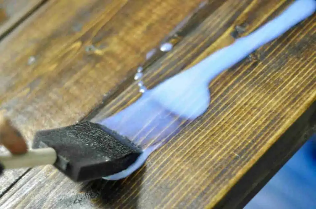 painting polycrylic onto a wood table.