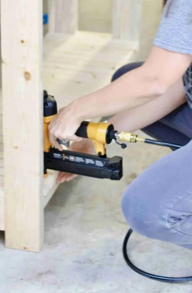 using a pneumatic nail gun to assemble table.