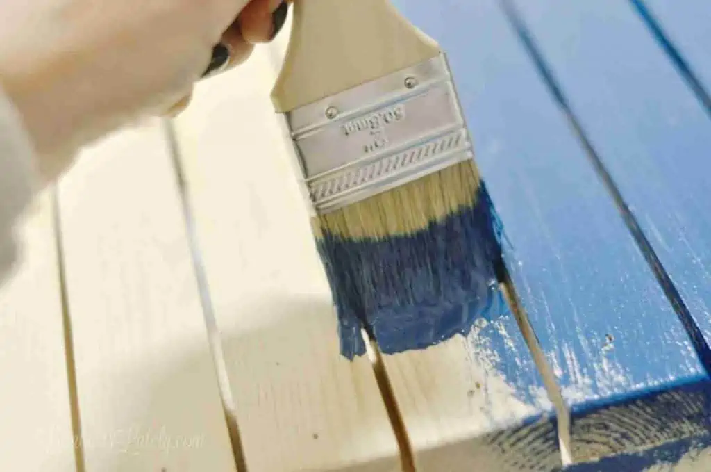 painting slats of a table blue.