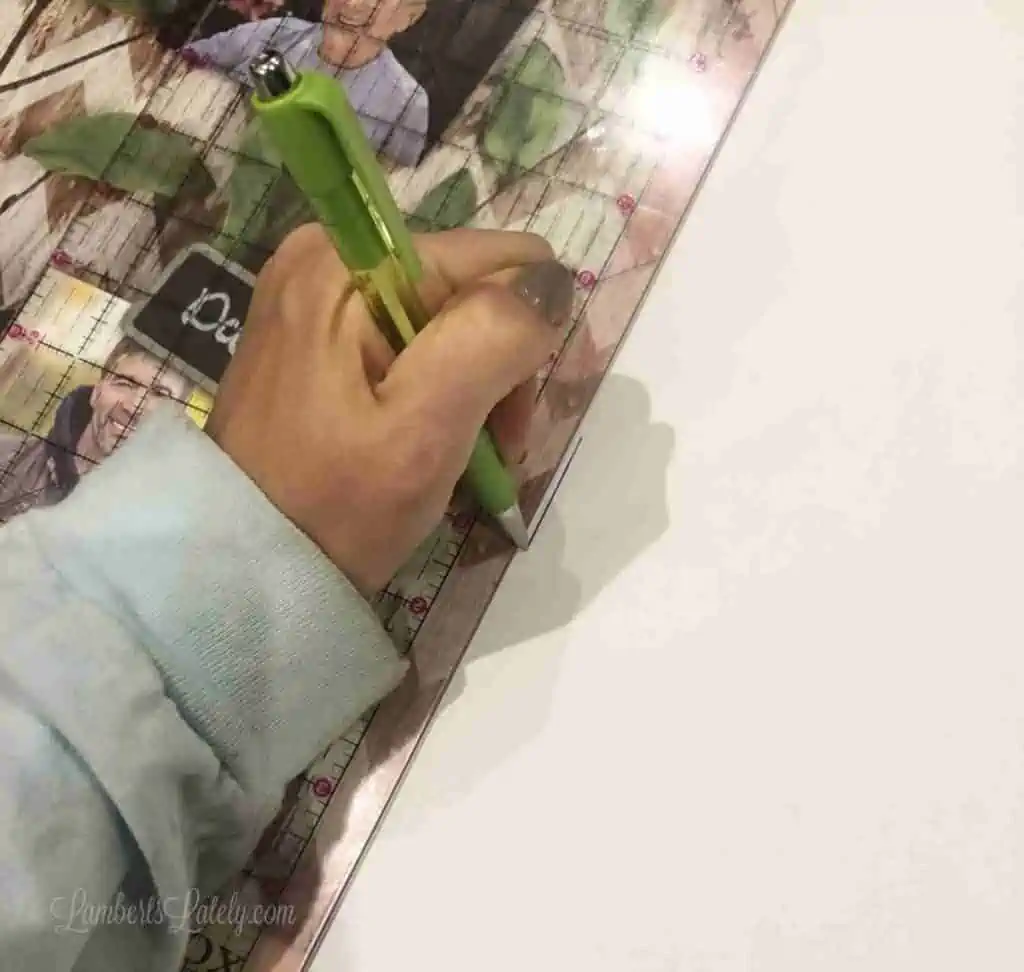 tracing outline of a frame onto fabric with a pen.