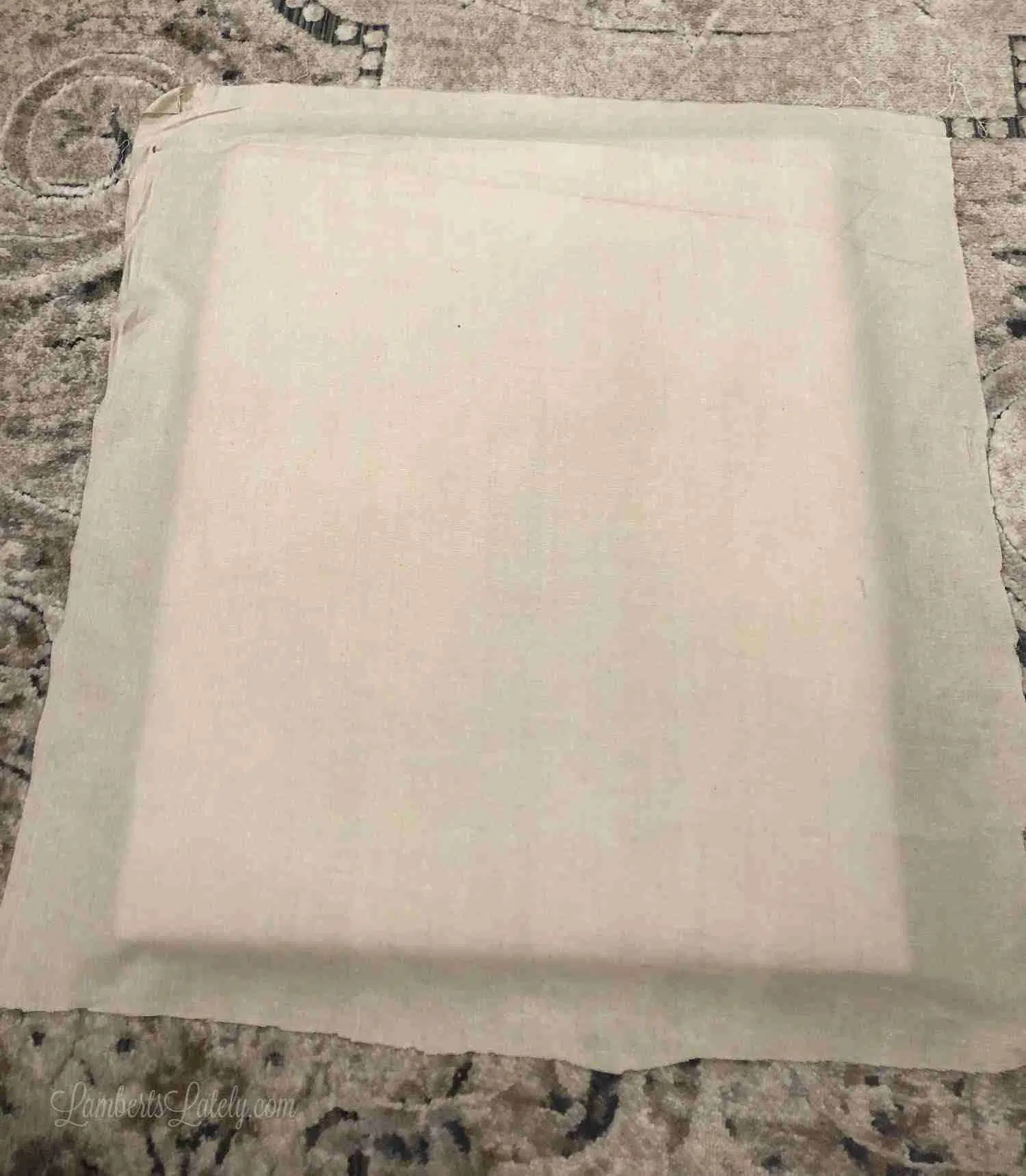 brown fabric laid out under the back of a frame.