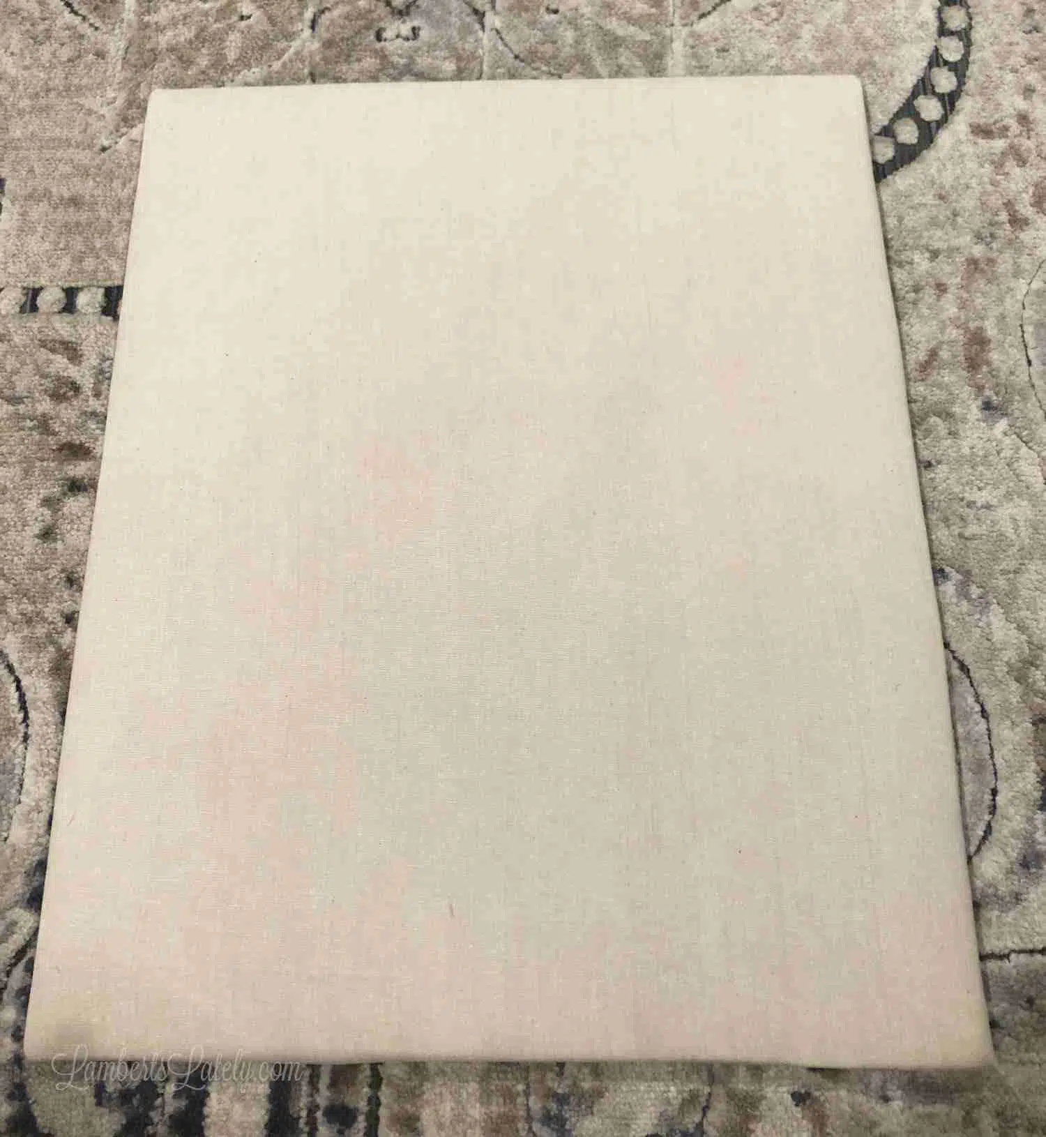 brown cloth wrapping the back piece of a shadow box.