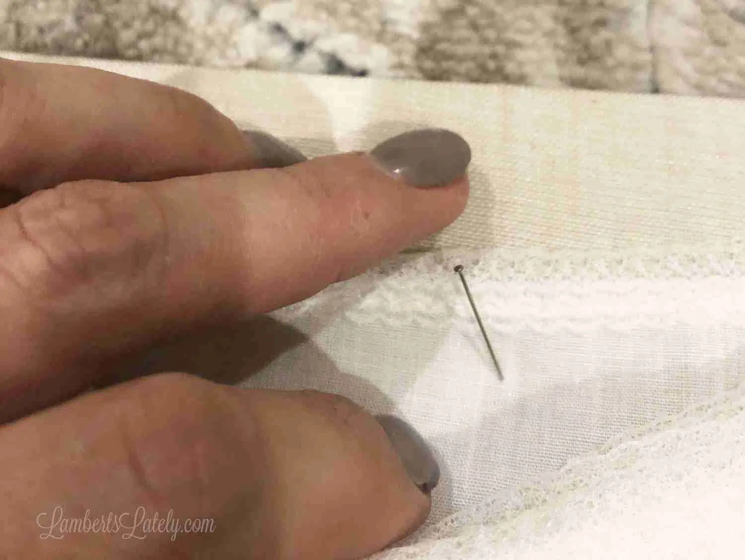 pushing a pin into fabric.
