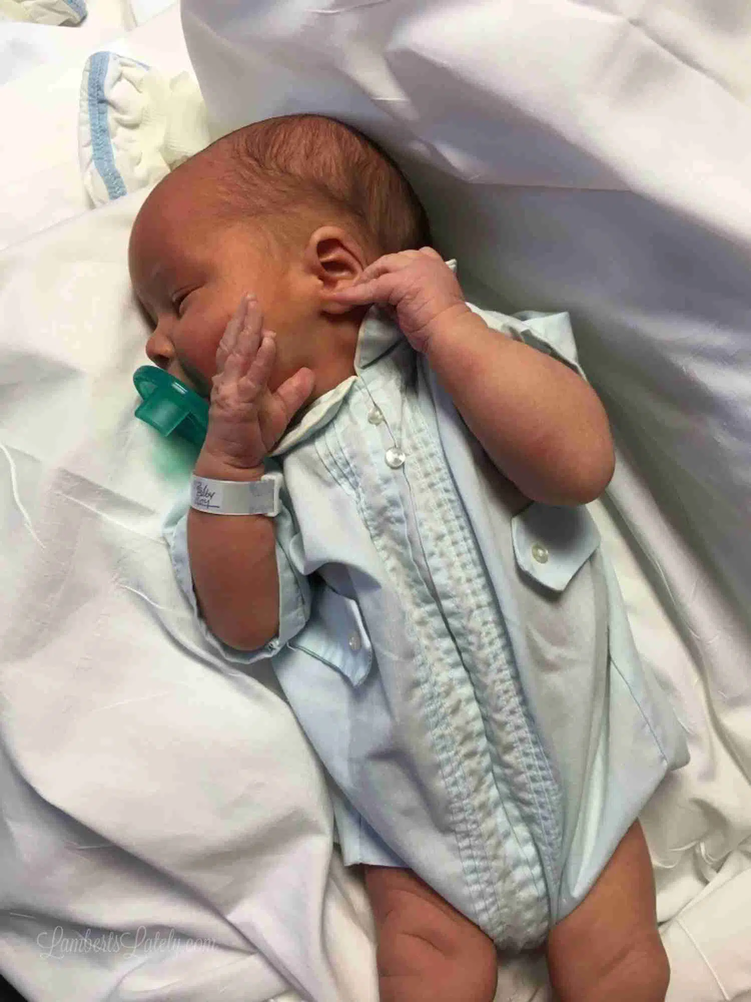 newborn in a blue outfit.