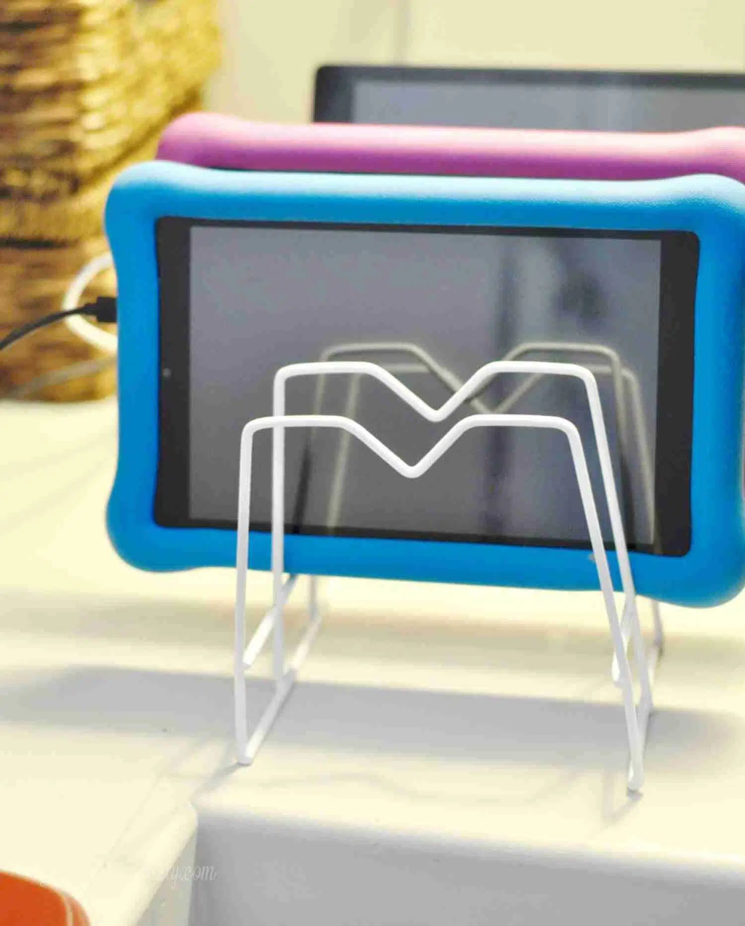 tablets organized in a dish rack on a desk.