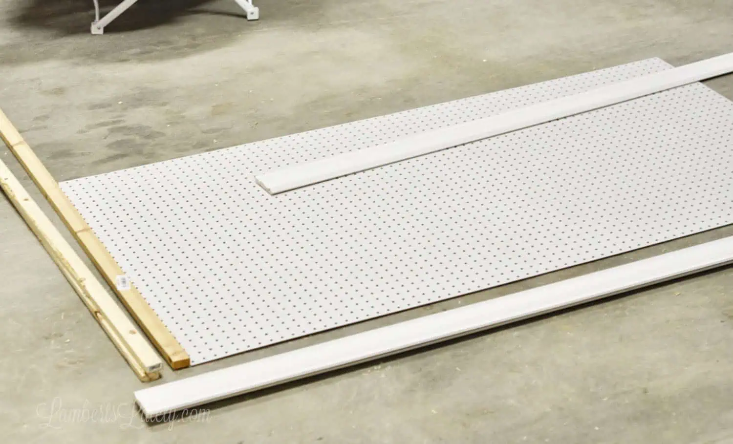pegboard, molding, and lumber laying on a garage floor.