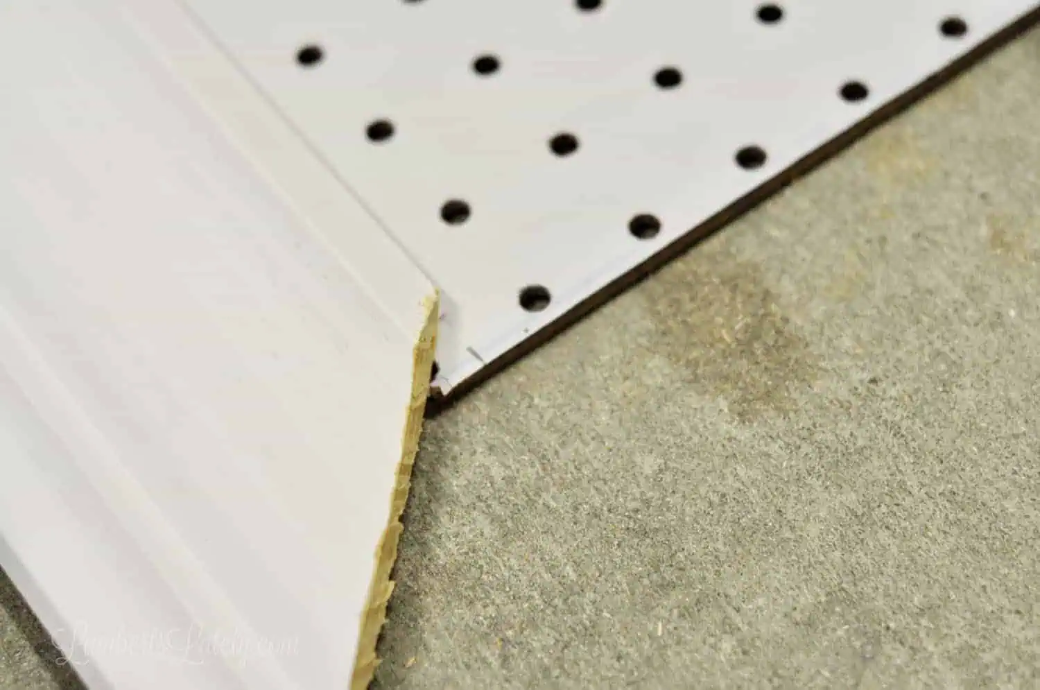 measuring angled crown molding against pegboard mark.
