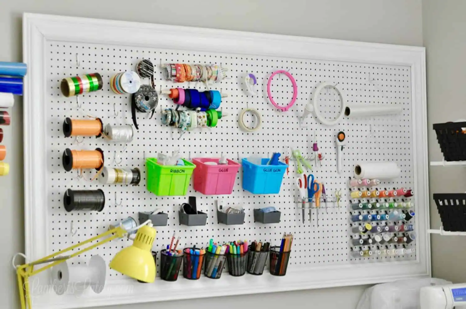 large rectangle craft room pegboard with colorful accessories.