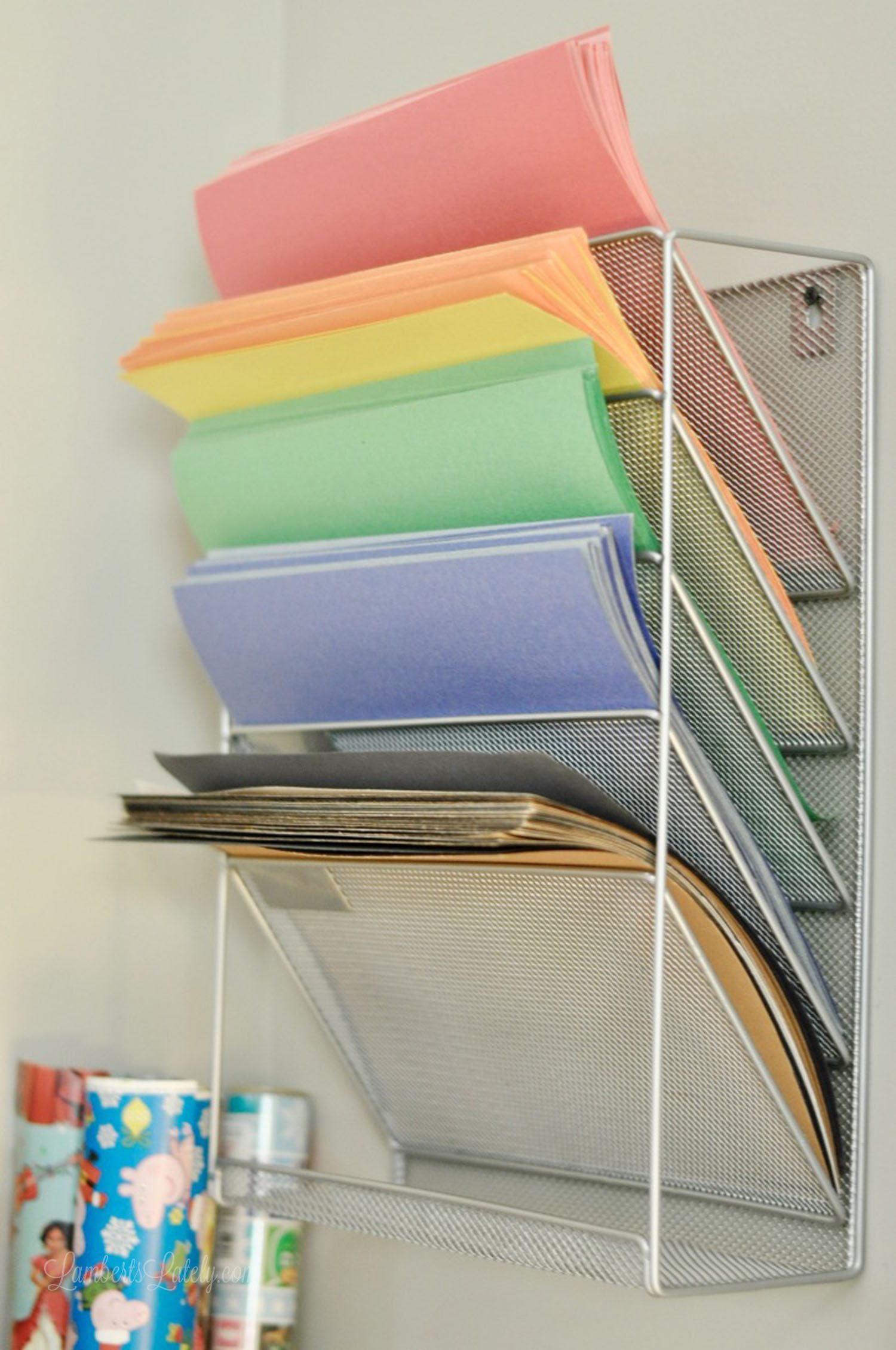 construction paper organized in a metal holder on a wall