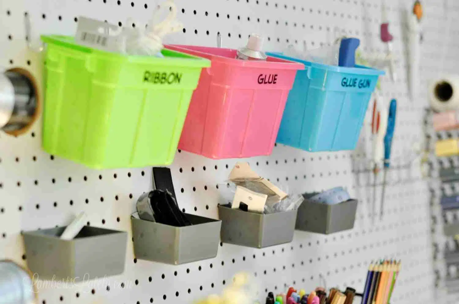 small plastic bins hanging on a peg board