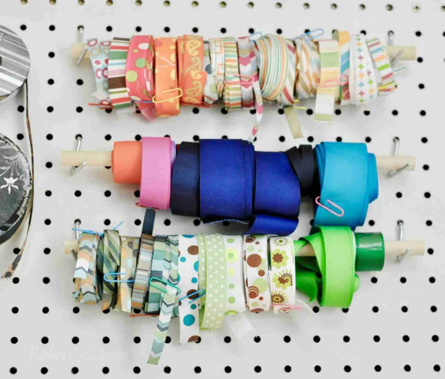 ribbon hanging on a wooden dowel on a peg board