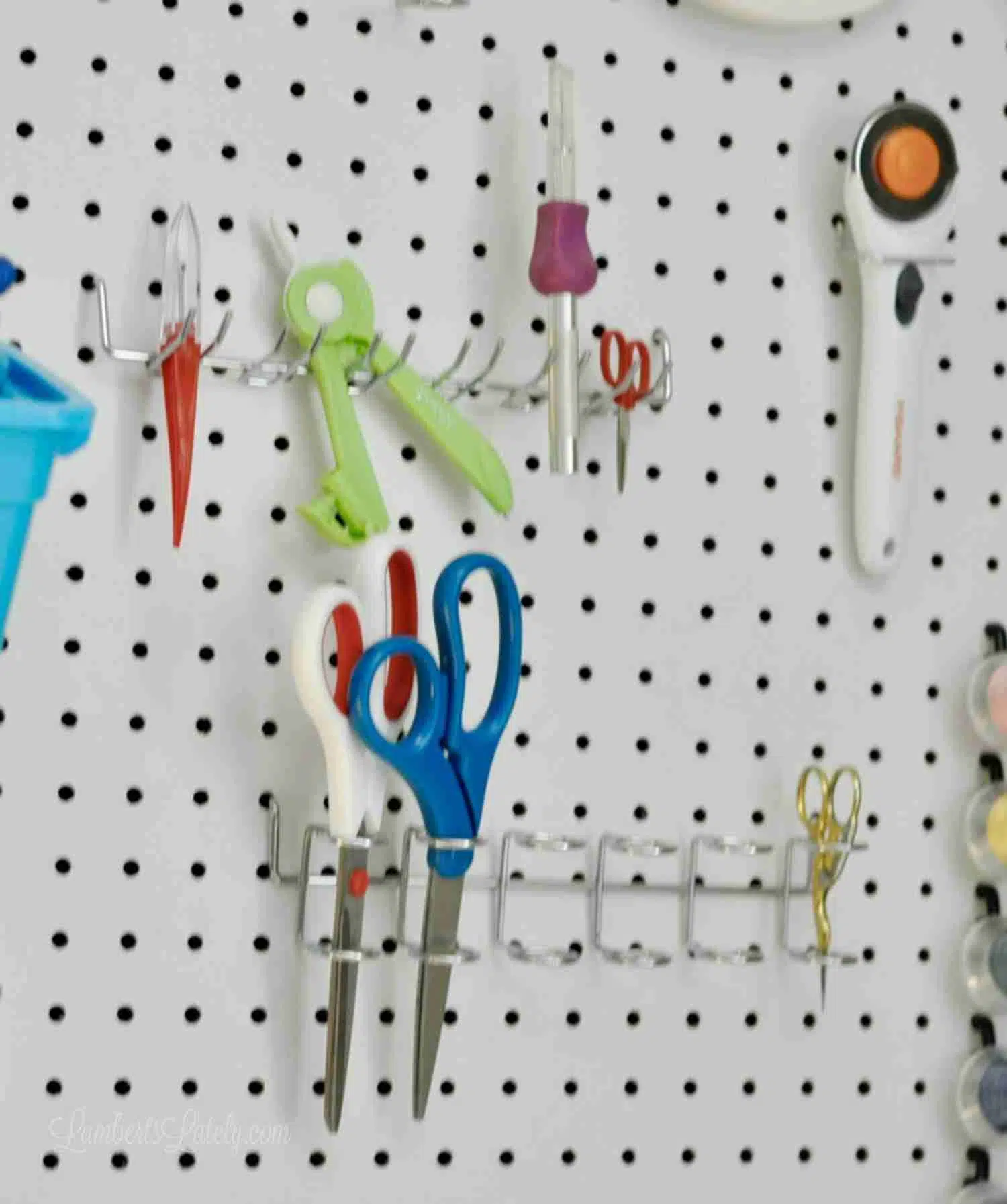scissors and cutting tools organized on a peg board