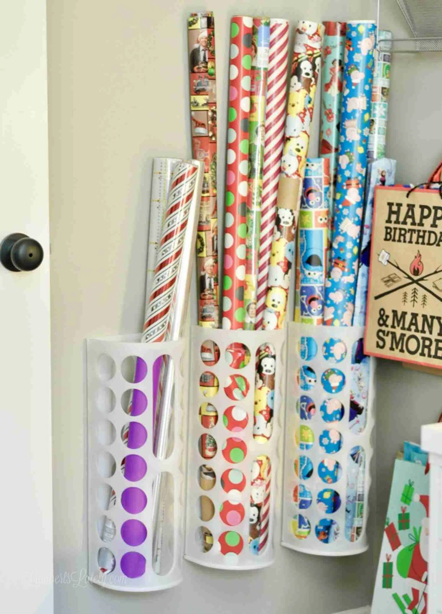 Ikea bag holders hanging on a wall, holding rolls of gift wrapping paper