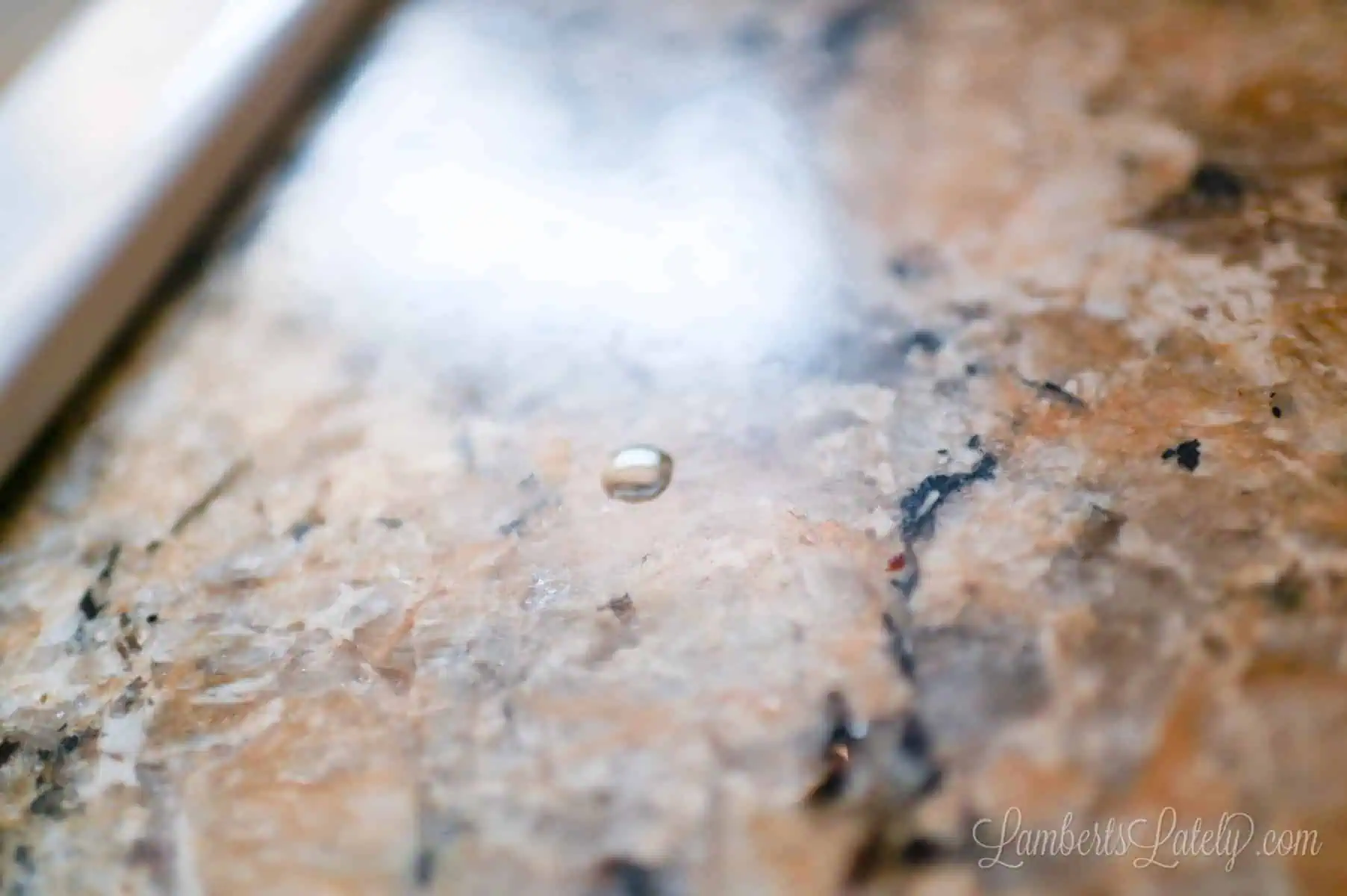 drop of water on alaskan white countertop.