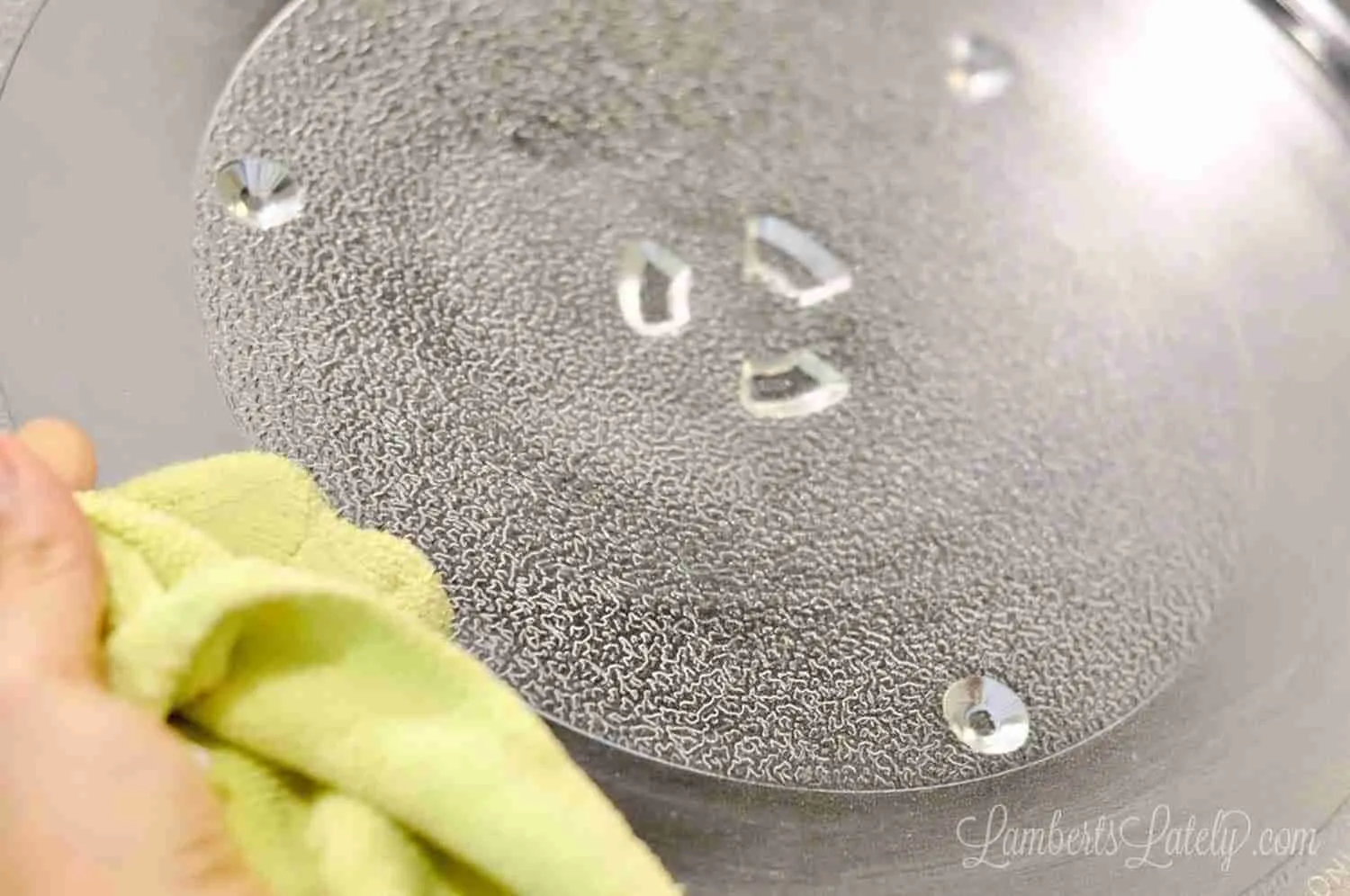 cleaning the turntable of a microwave with microfiber cloth