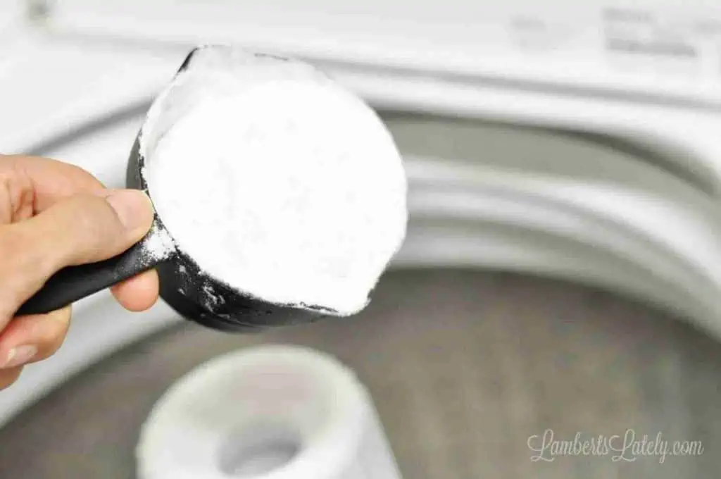 pouring baking soda into a washing machine.