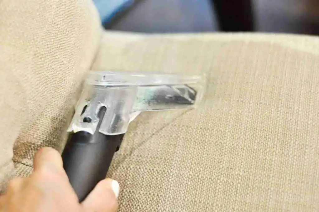 using a upholstery cleaner on a chair.