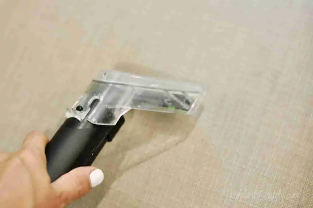 using an upholstery cleaner to rinse a fabric chair.