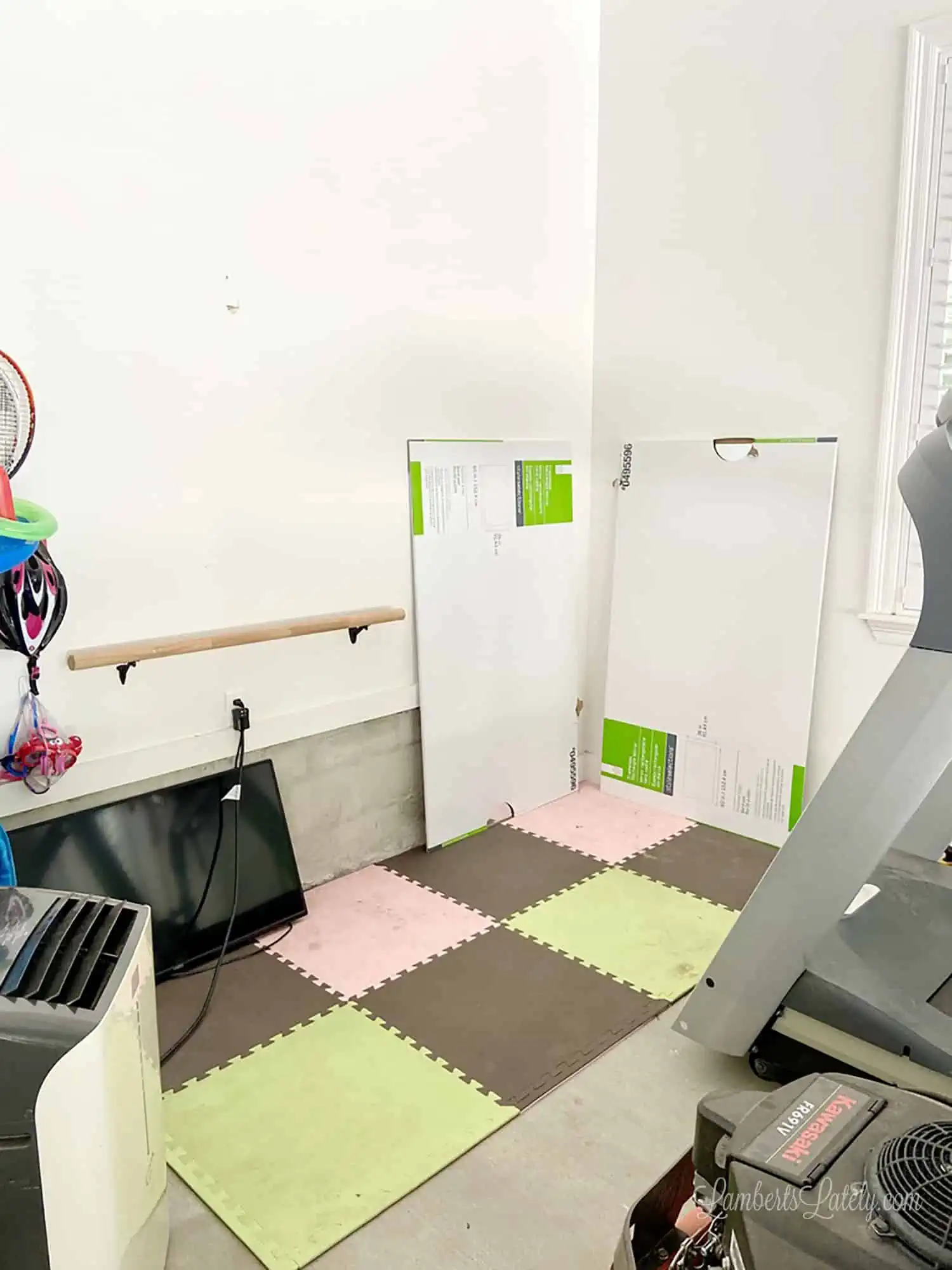 building a home gym, with mirrors, a tv, a barre, and foam flooring.