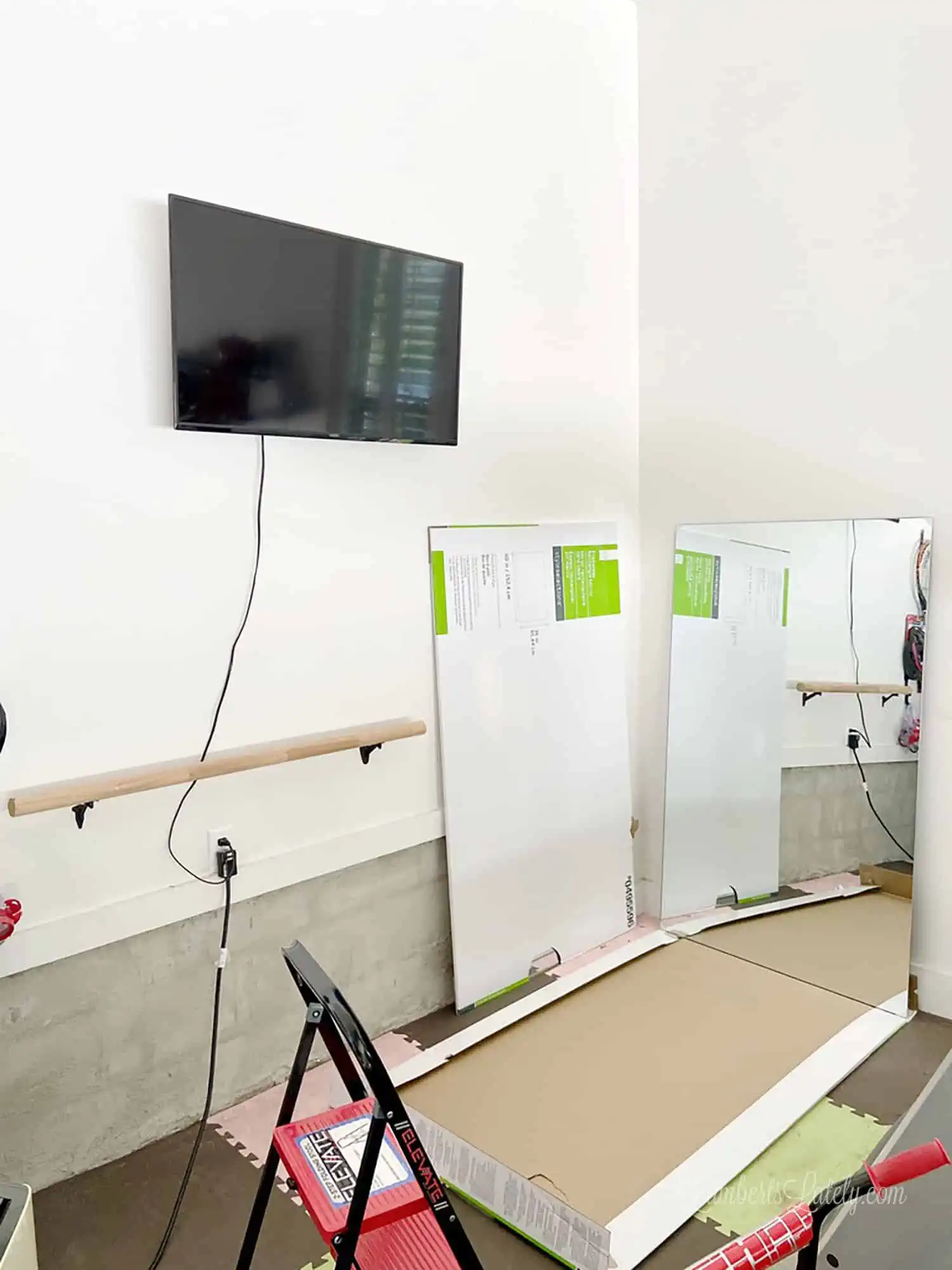 making a home gym - tv on wall, mirror not yet hung.