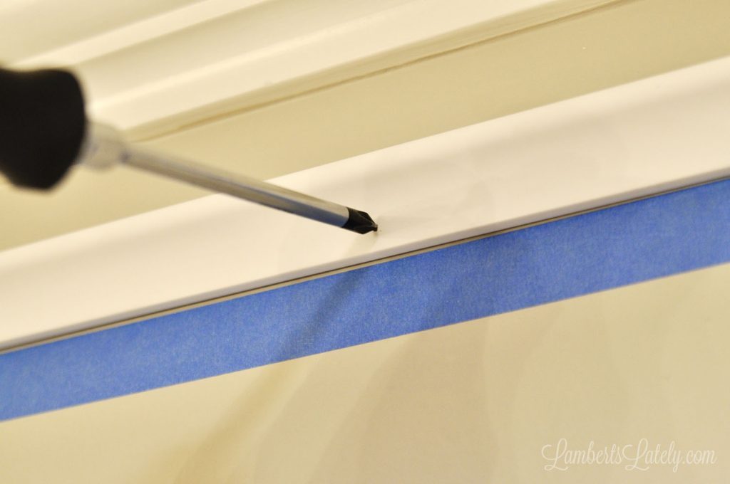 poking nails into molding with a screwdriver.