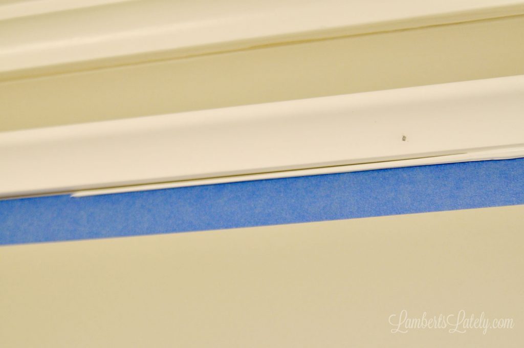 showing nail holes in molding, with blue painters tape below.