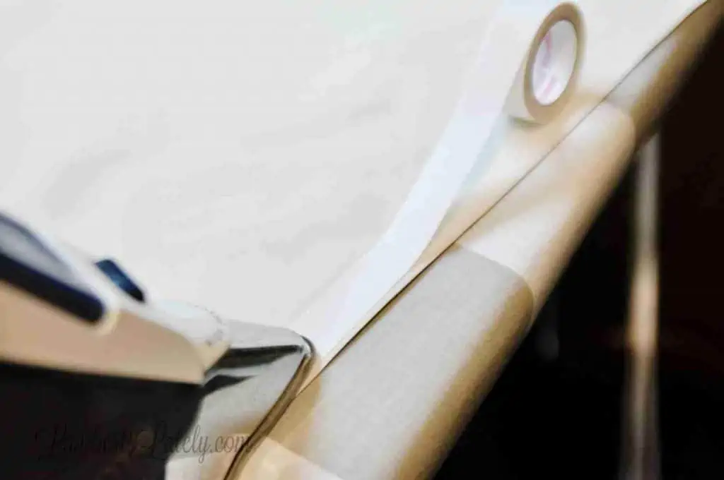 ironing hem tape onto curtain.