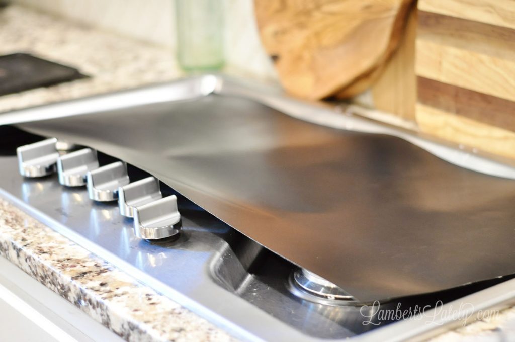 measuring oven liner on a stove top