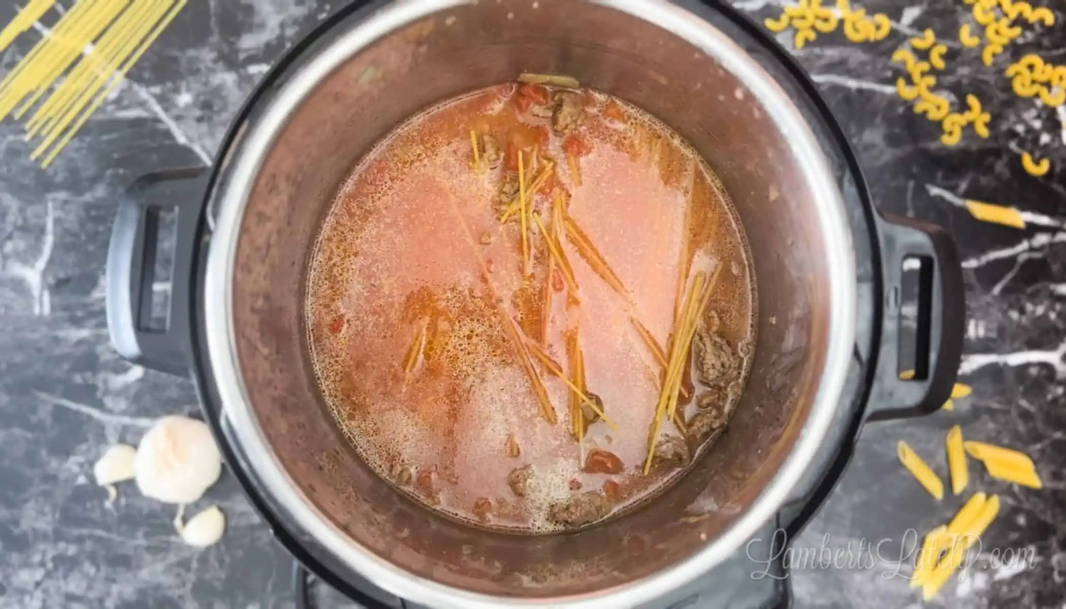 pasta noodles in tomatoes and water in an instant pot.