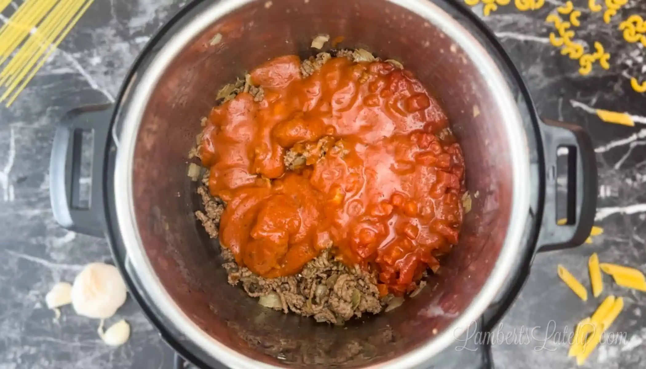 sauce over ground beef and onion in an instant pot.