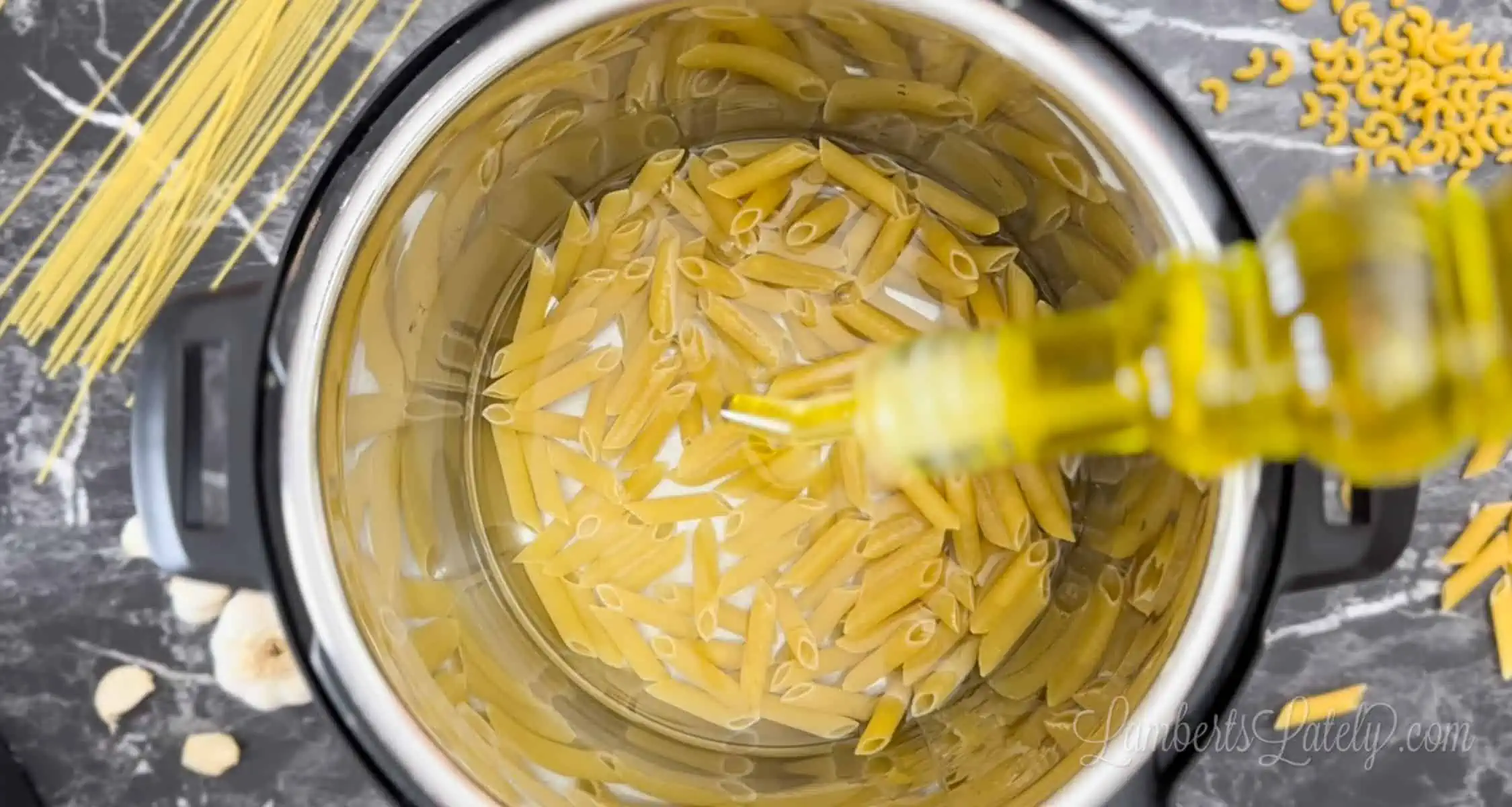 adding olive oil to pasta and water in an instant pot.