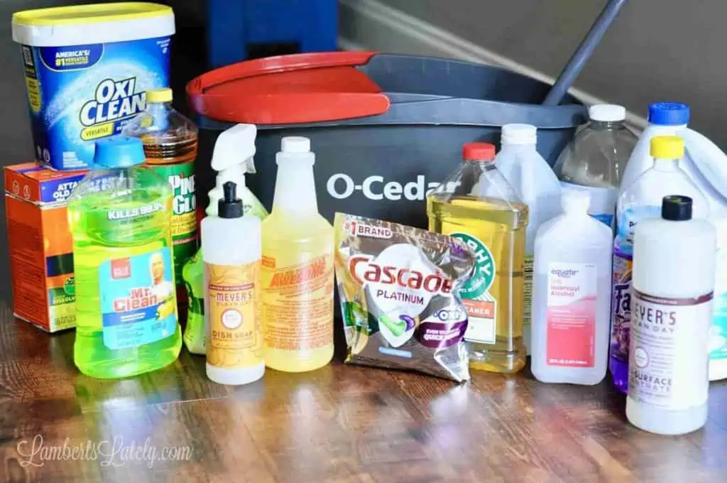 different cleaners on a floor in front of a mop bucket.