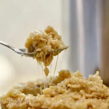 holding a fork of cheesy chicken and rice in front of an instant pot.