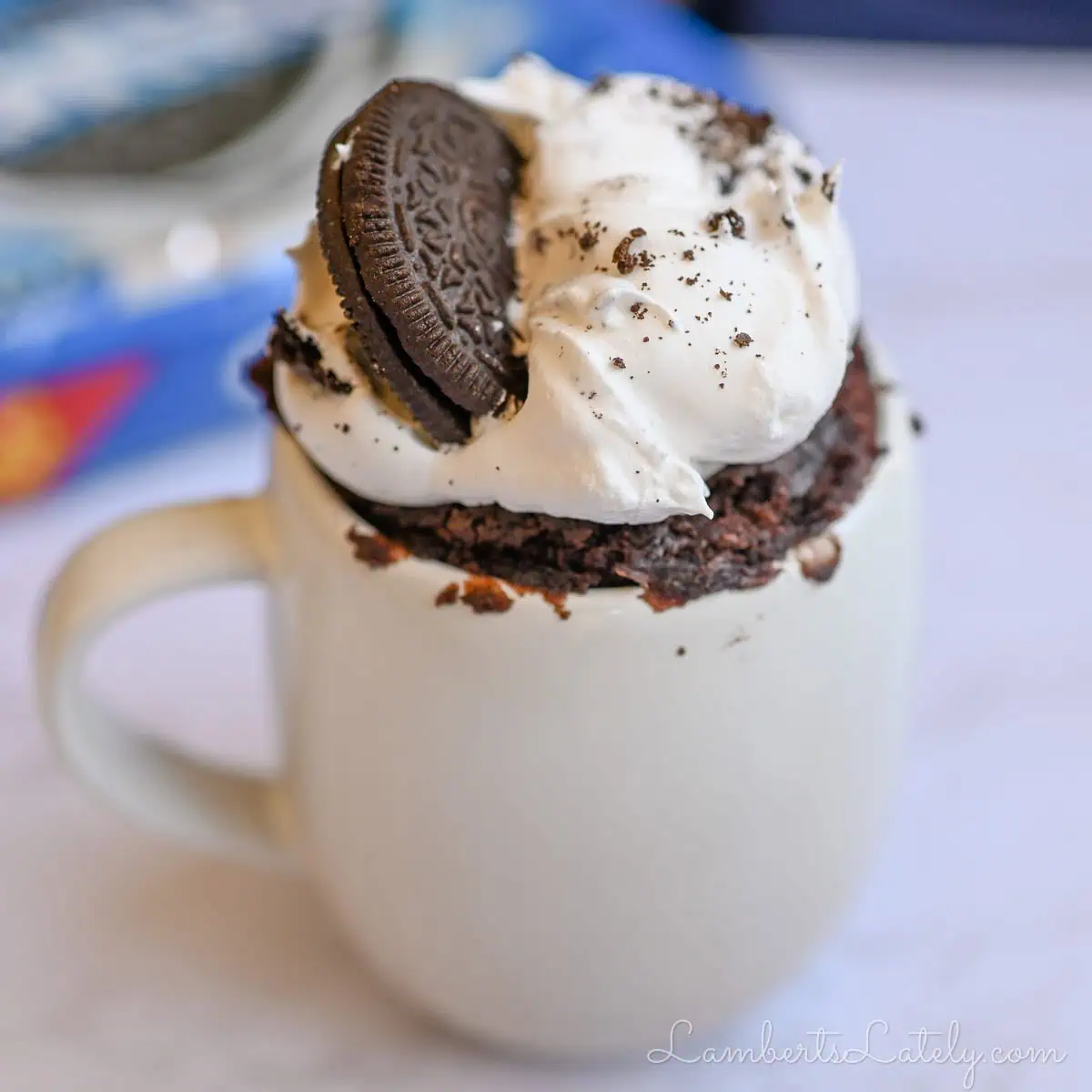 oreo mug cake covered in whipped cream.