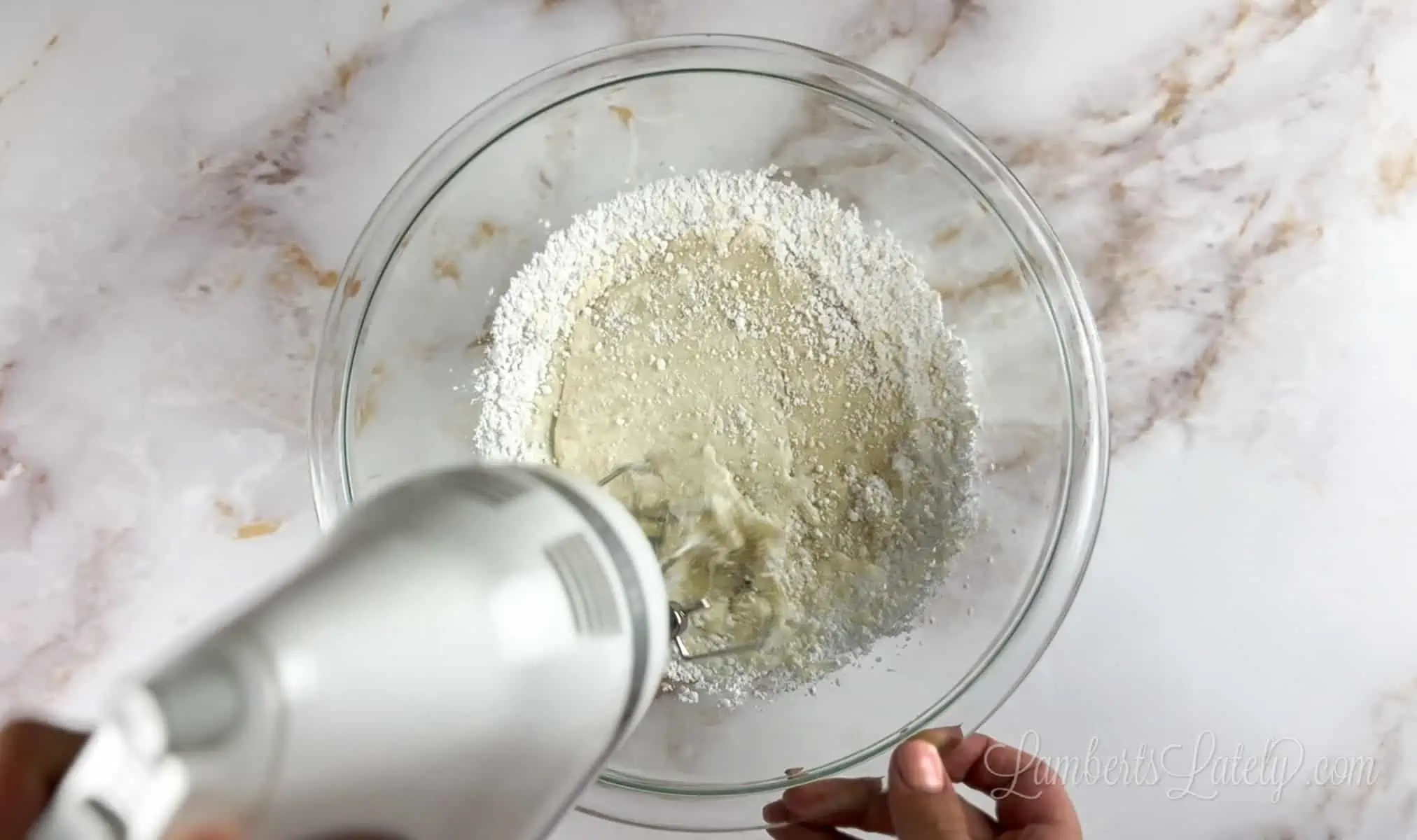 combining ingredients in a bowl with a mixer.