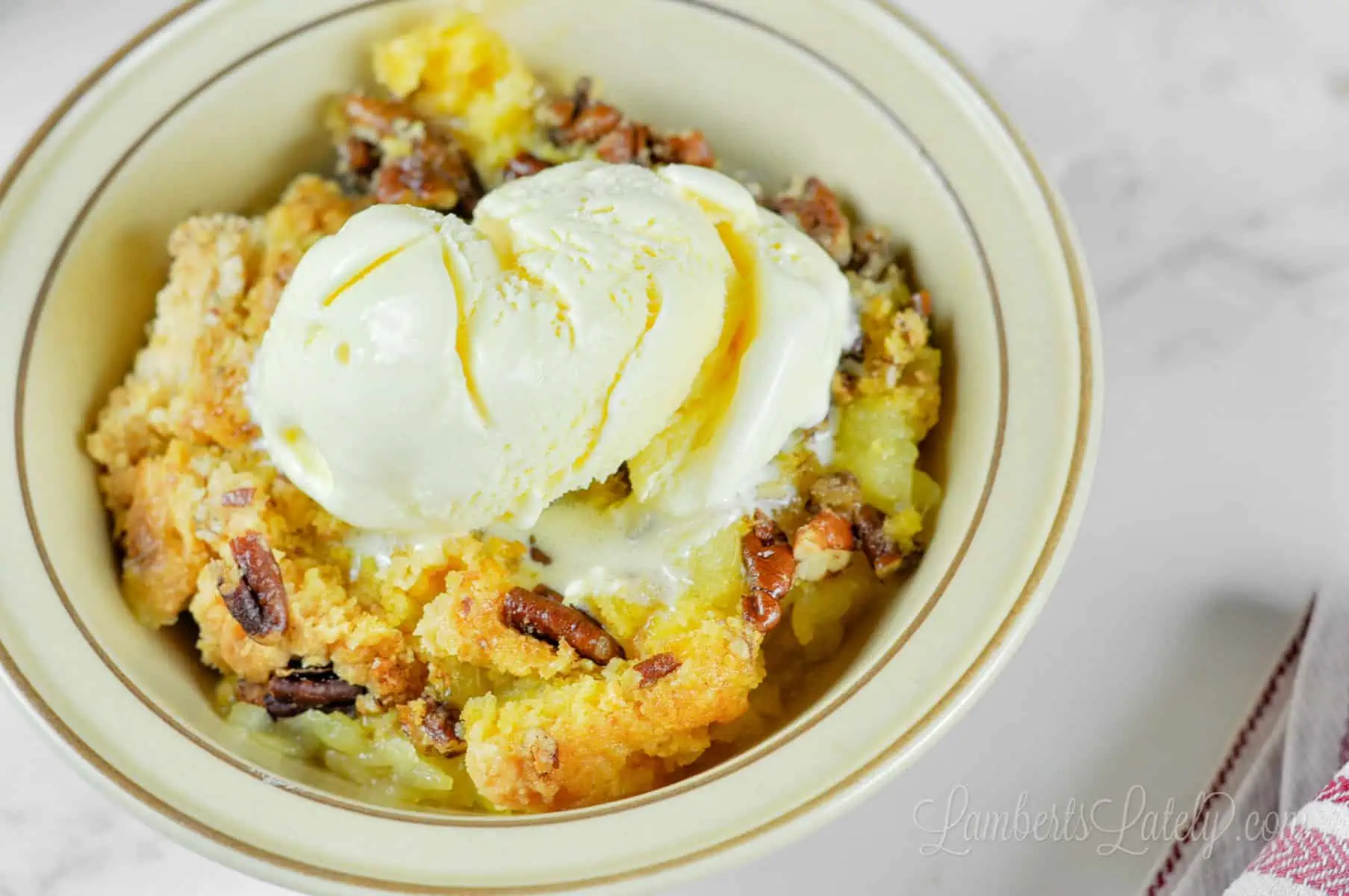 bowl of pineapple dump cake with ice cream.