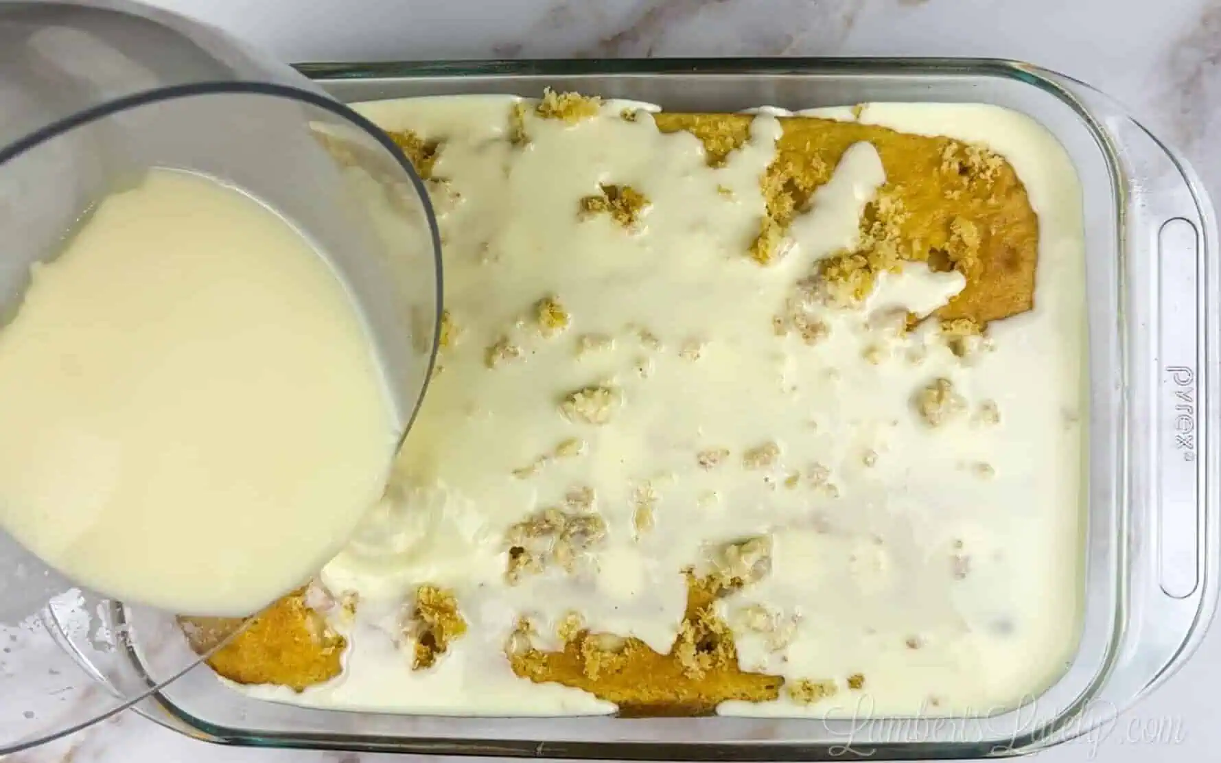 pouring pudding mix over a banana cake.