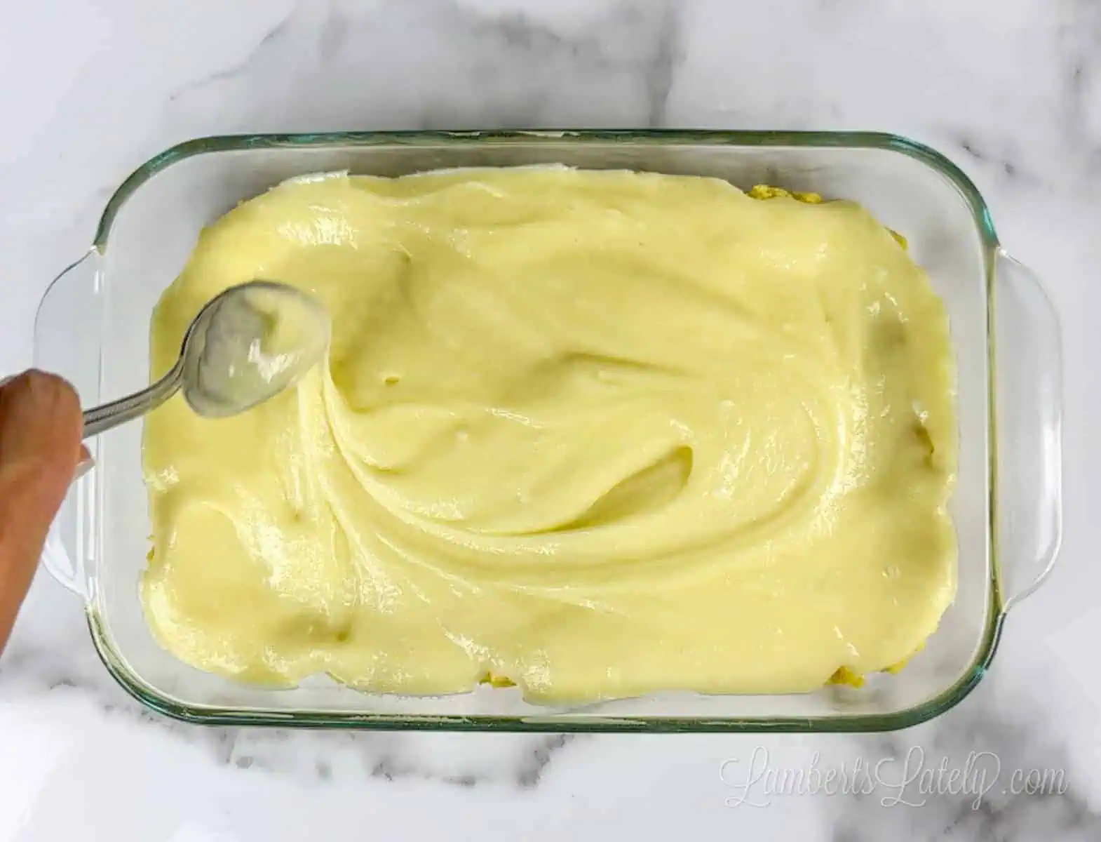 spreading cream cheese mixture over lemon cake mix.