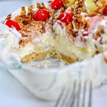 close up of cut out piece of banana split cake in a glass dish.