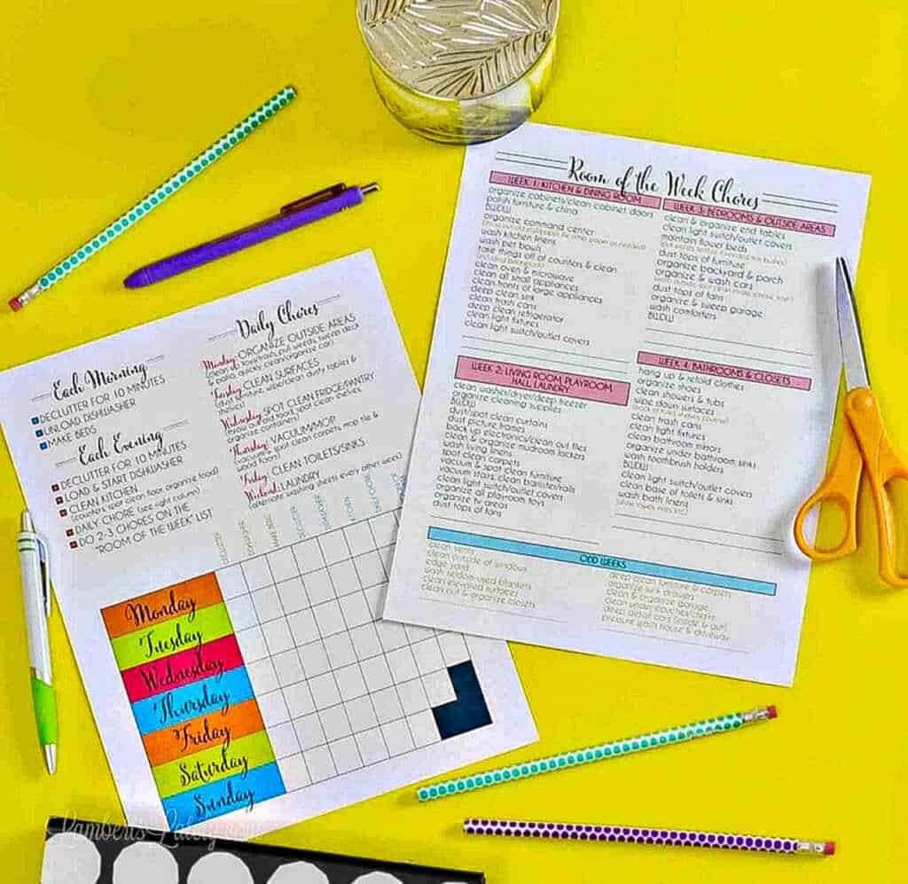 two cleaning schedule printables on a desk.