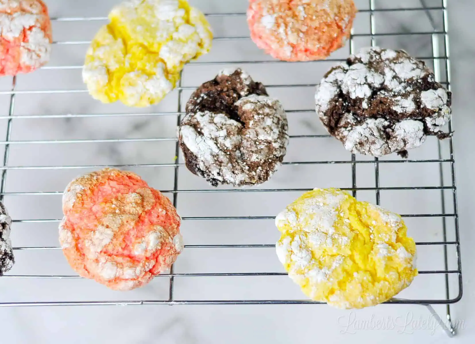lemon, chocolate, and strawberry cool whip cookies on a baking rack.