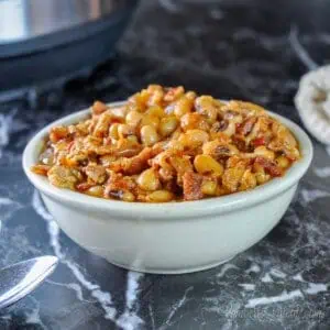 bowl of black eyed peas in front of an instant pot on a black counter.