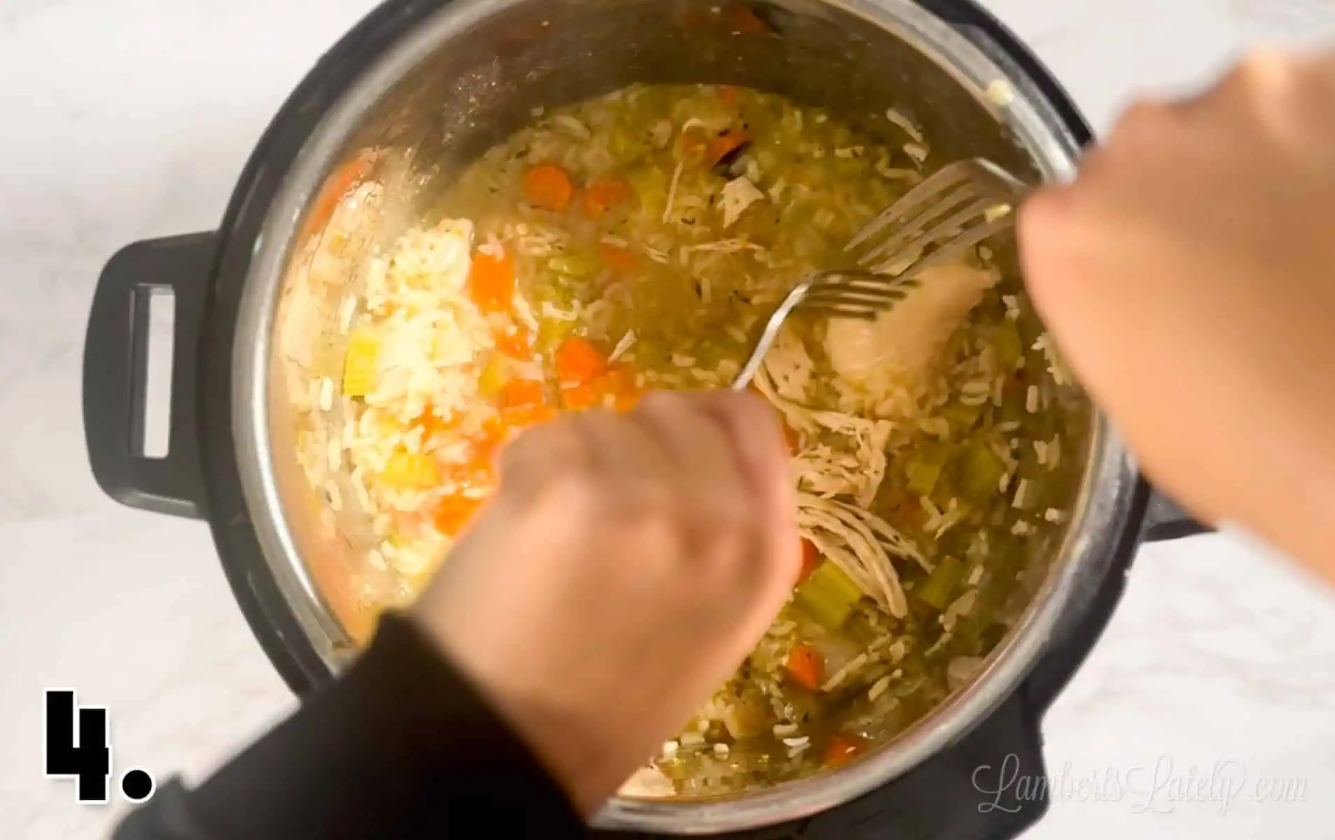 shredding chicken with two forks after soup has cooked.